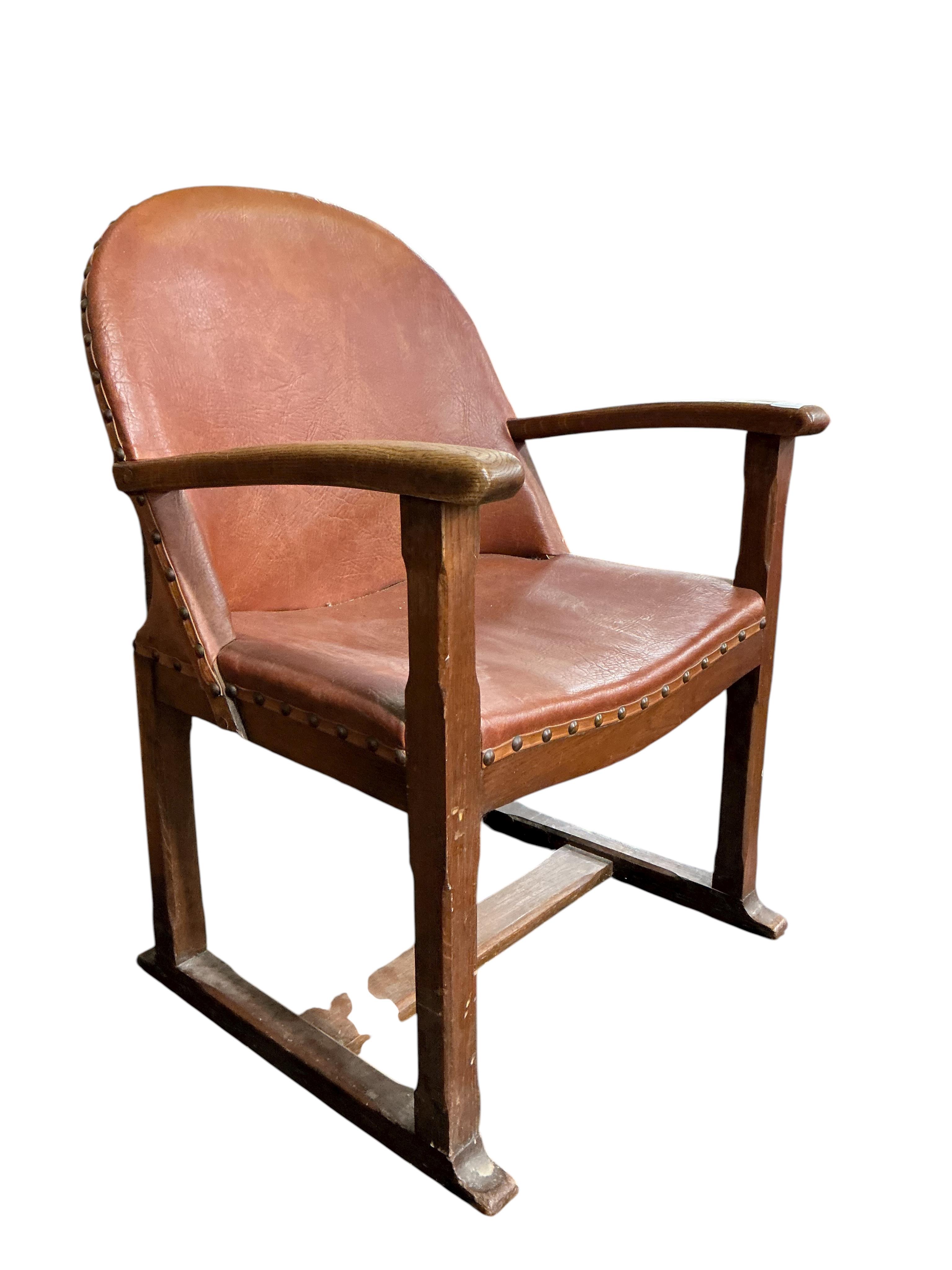 A 1920's oak Arts and Crafts leather upholstered desk chair, width 57cm, depth 42cm, height 82cm